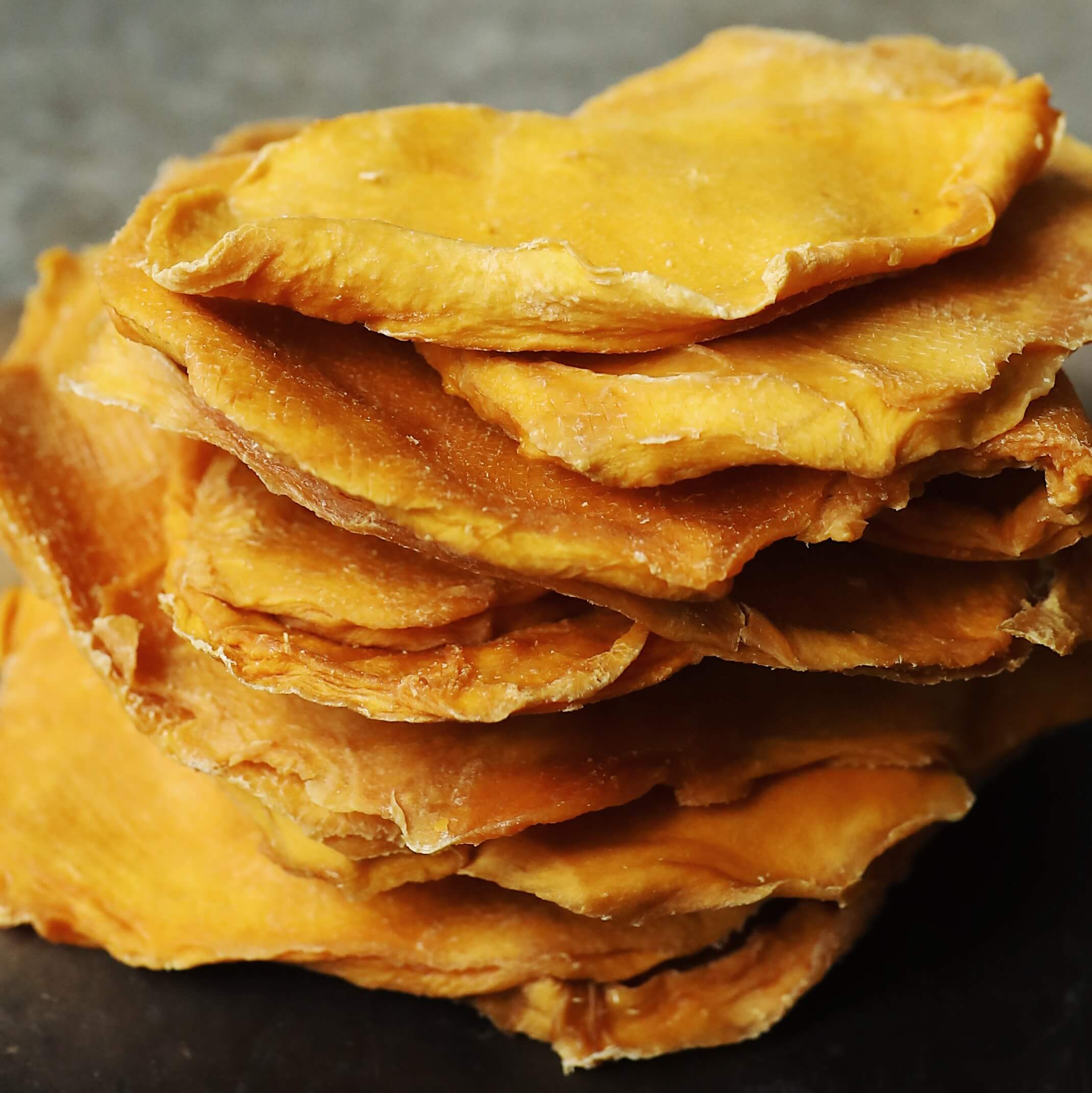 Stack of organic dried mango cheek.