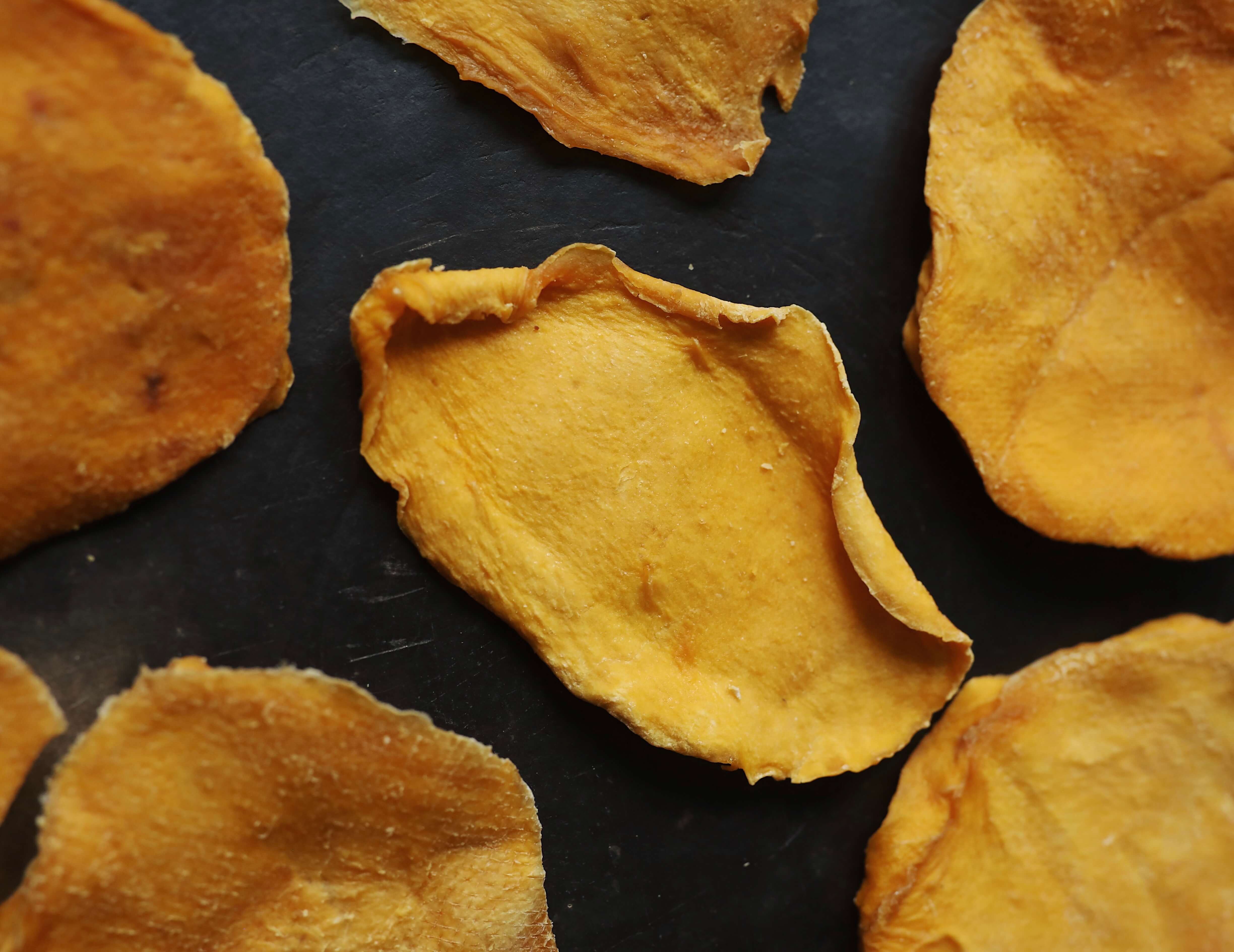 Bright yellow organic dried mango cheeks.