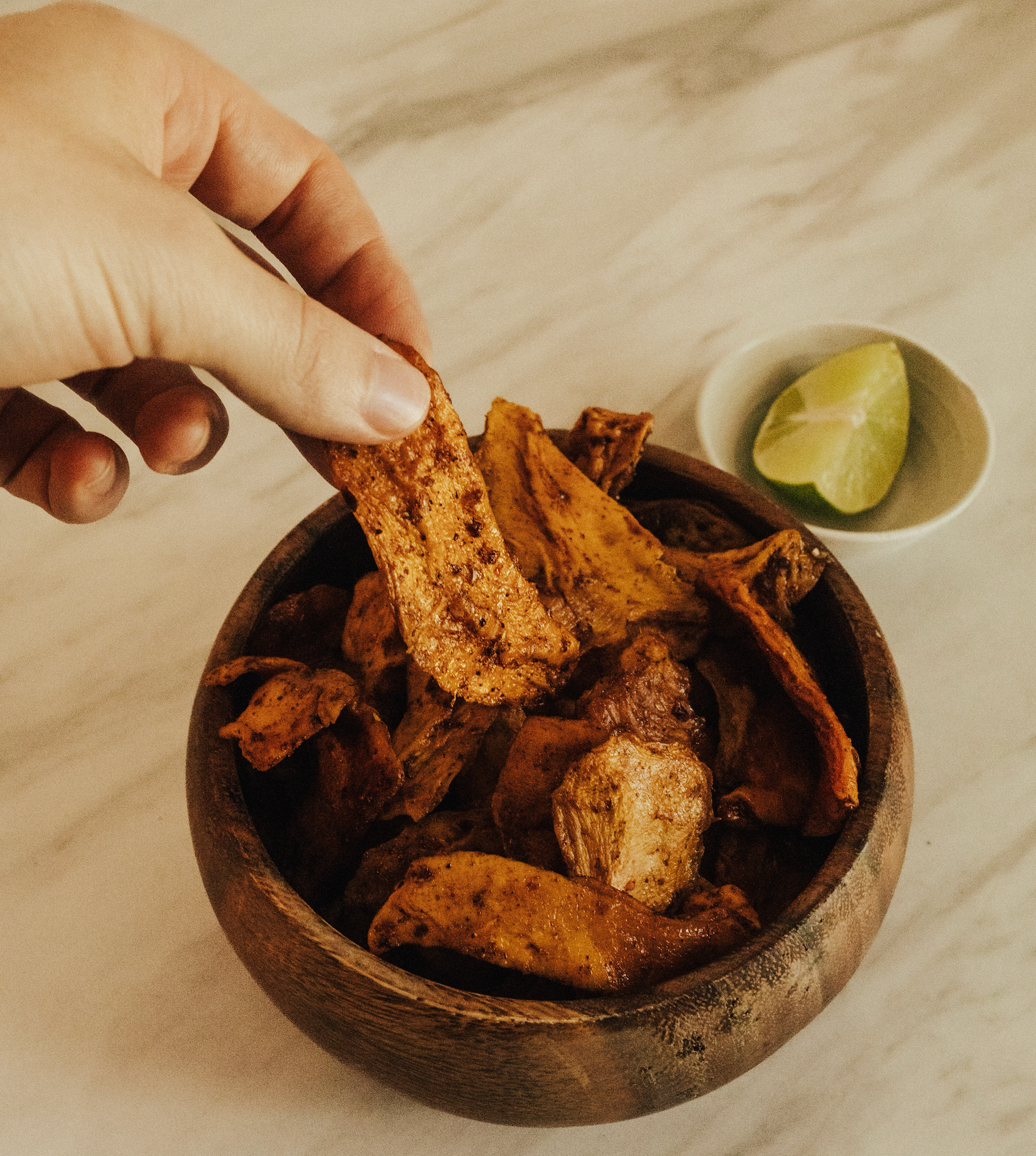 hand reaching for chili lime dried mangoes